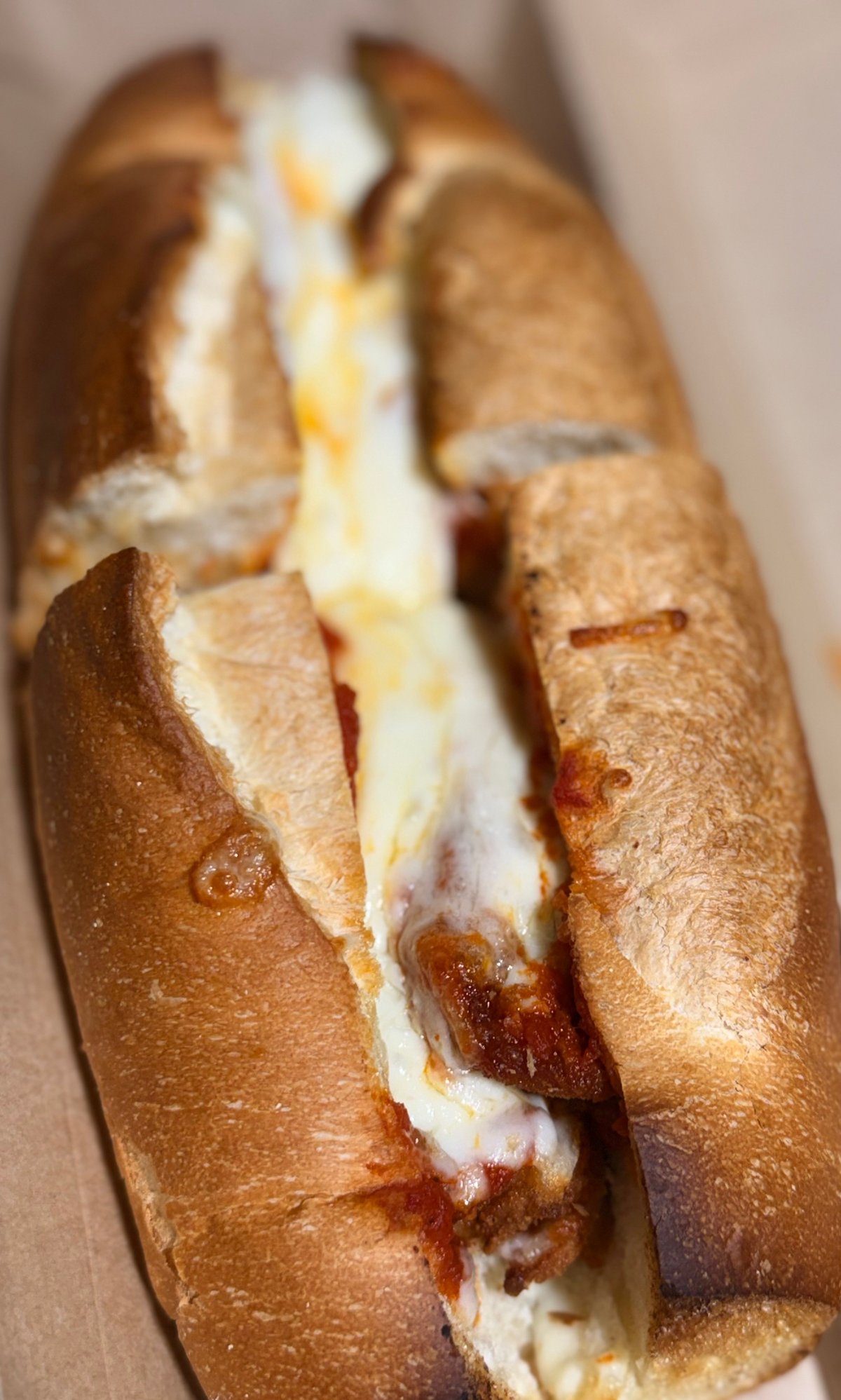 Crispy baguette sandwich filled with melted cheese and ham